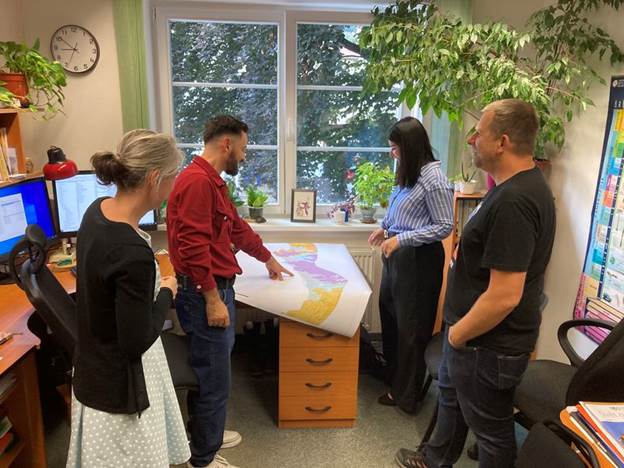 A group of people standing around a table

AI-generated content may be incorrect.