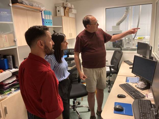 A group of people standing in a room

AI-generated content may be incorrect.